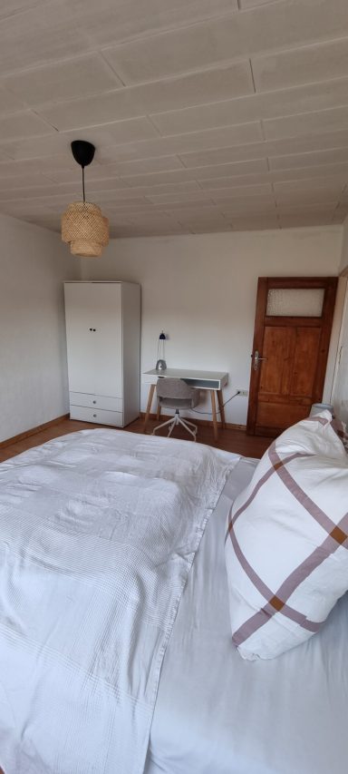 Schlafzimmer mit Bett und Kleiderschrank